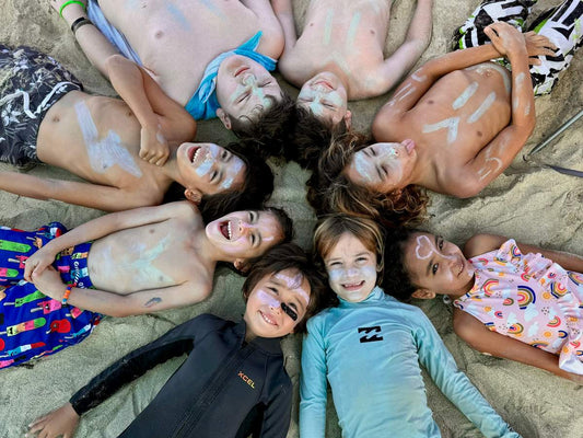Wild Thingz Botanicals Children Laying down in sand circle All Mineral Reef Safe SPF30 Sunscreen Sunsticks in Fun Colors